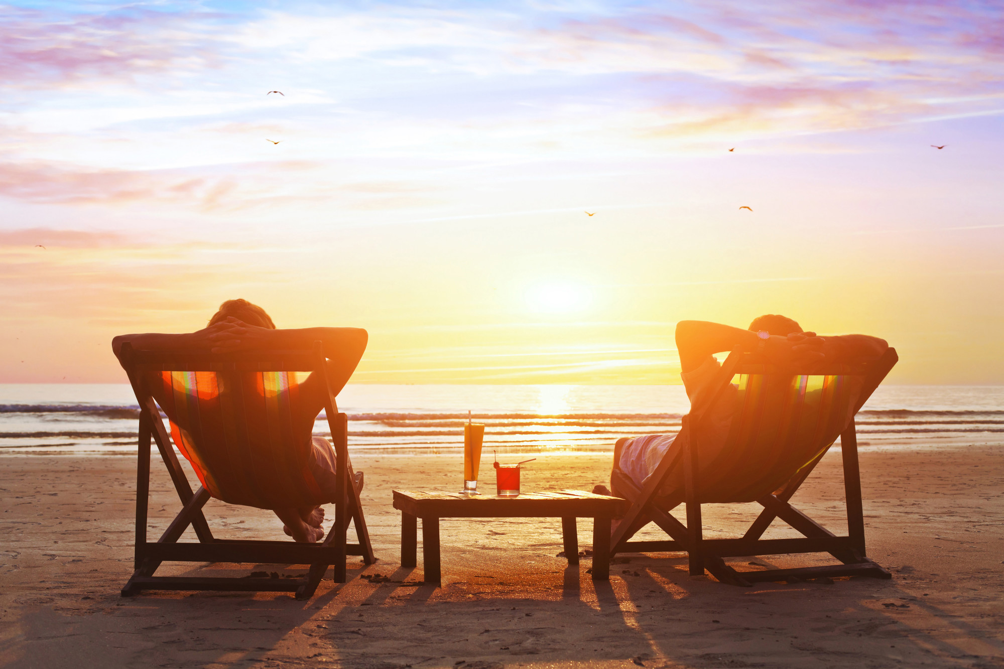 Madeira Beach Winter Vacation Couple on beach in 2 chairs with table in the middle